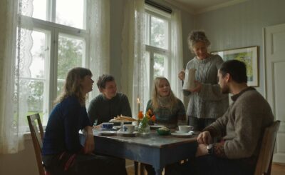 En gruppe mennesker sitter rundt et kafebord og får servering. Foto