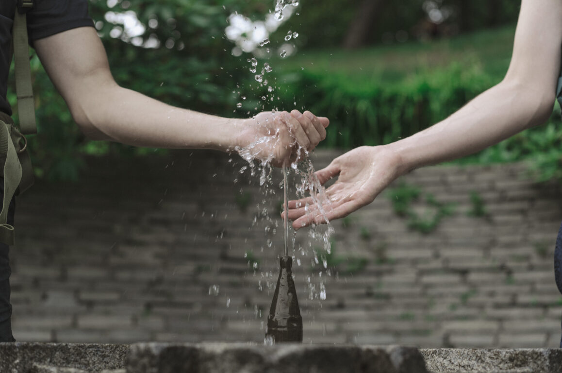 pilgrims touching the water from the holy spring