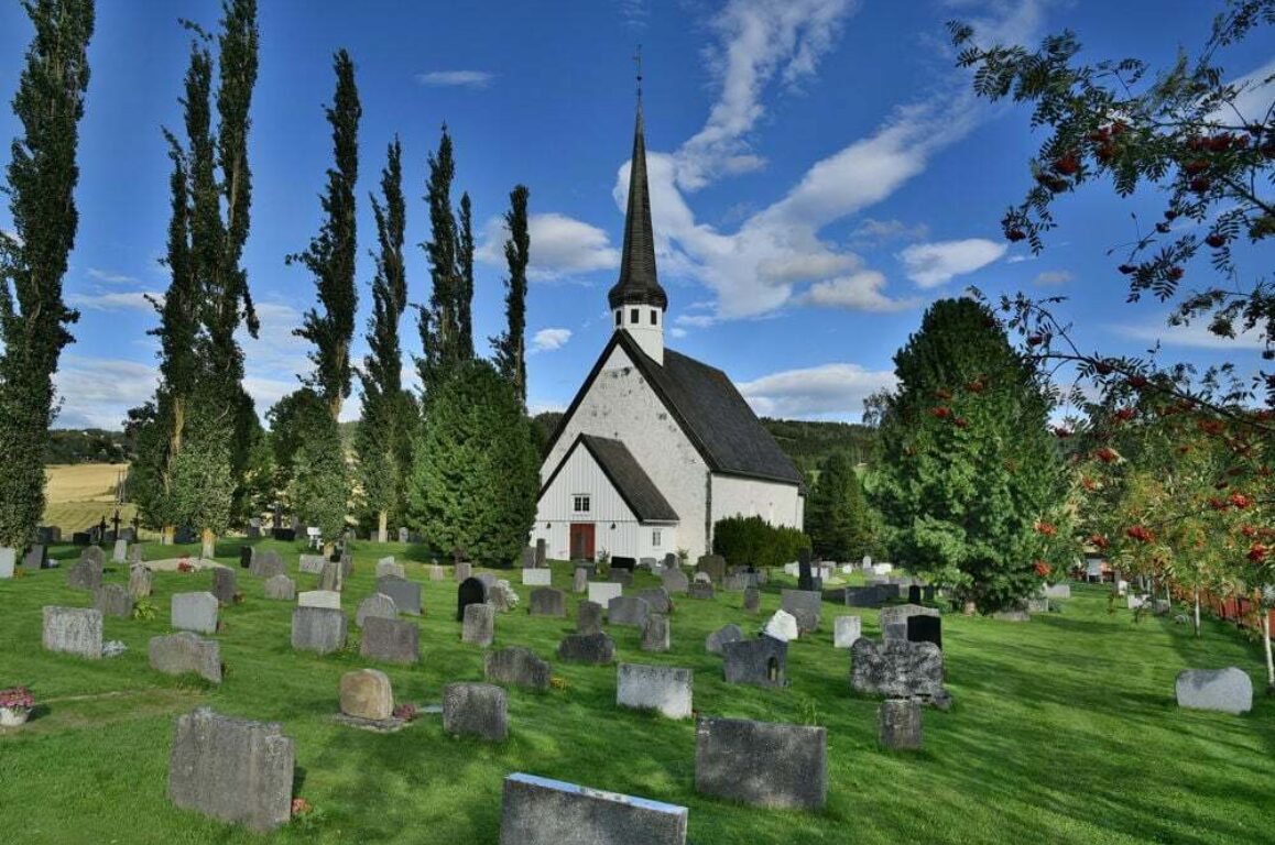 White stone church from the middleages in green surroundings.